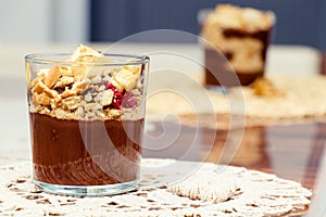 Delicious dessert with banana and biscuits chocolate pudding in glass cup on table