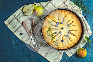 Delicious dessert blueberry tart with fresh berries and pears, sweet tasty cheesecake, berry pie on dark blue concrete surface