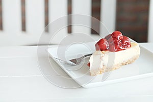 Delicious with dessert a piece of cherry cheesecake on white tone wooden table