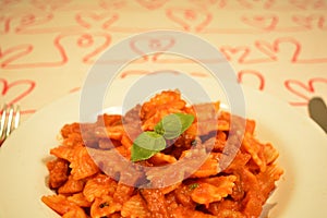 Delicious dish of an italian pasta. Bow tie noodles with tomato and basil, recipe from Rome, Italy