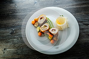 Delicious dissected chicken Kiev cutlets with grilled vegetables and sauce