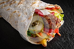 A delicious doner donair kebab wrap with meat, lettuce, tomato, red onion photo