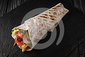 A delicious doner donair kebab wrap with meat, lettuce, tomato, red onion photo