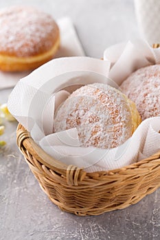 delicious donuts berliners with filling sprinkled with powdered sugar in basket on a grey background photo