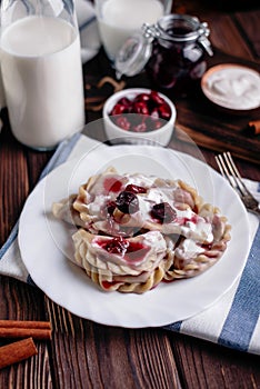 Delicious dumplings with cherries, sour cream and jam