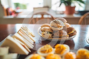 Delicious easter brunch with homemade sandwiches, buns and filled eggs on a wooden kitchen table