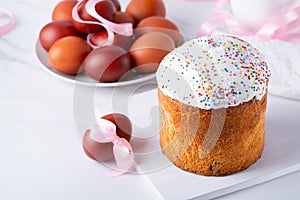 Delicious Easter cake and eggs on white background