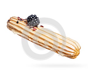 Delicious eclair with blackberry close-up on a white background