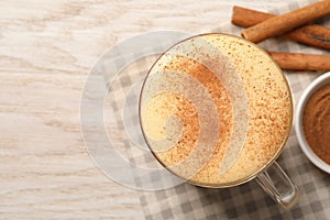 Delicious eggnog with cinnamon on wooden table, top view. Space for text