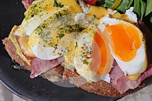 Delicious eggs benedict with spinach and ham on a toast