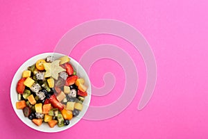 Delicious exotic fruit salad on pink background, top view. Space for text