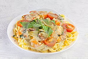Delicious fettuccine pasta with prawns on white plate