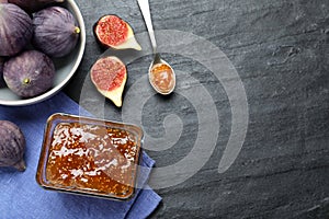 Delicious fig jam and fresh fruits on black table, flat lay. Space for text