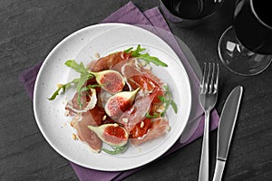 Delicious figs and proscuitto on plate, flat lay