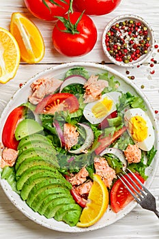 Delicious fish salad salmon or tuna with lettuce, tomatoes, red onion, eggs and avocado with dressing of olive oil , mustard and