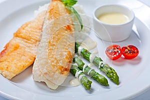 Delicious fish steak with green asparagus and rice photo