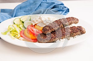 Delicious flatbread wrap koobideh with fresh vegetables and tzatziki sauce