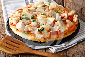 Delicious food: buffalo pizza with chicken breast, tomato concasse and mozzarella cheese close-up. horizontal photo