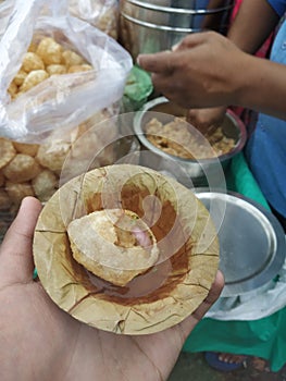 Delicious panipuri in hand beside the stall photo