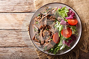 Delicious food: slow cooked pulled beef with fresh vegetable sal
