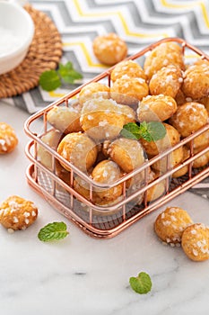 Delicious French Chouquette Choux Pastry dessert Pearl Sugar Puff on white marble background