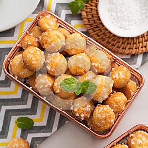 Delicious French Chouquette Choux Pastry dessert Pearl Sugar Puff on white marble background