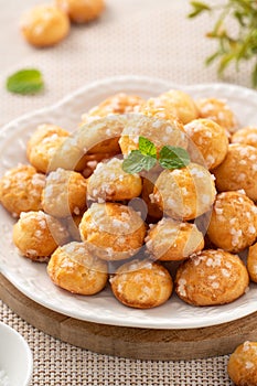Delicious French Chouquette Choux Pastry dessert Pearl Sugar Puff on wooden table background