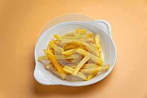 Delicious French fries on an orange photo