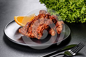 Delicious fresh baked pork ribs with orange on a black plate