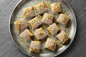 Delicious fresh baklava with chopped nuts on grey table, top view. Eastern sweets