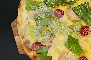 Delicious fresh cesar pizza with chicken and vegetables on wooden board