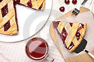 Delicious fresh cherry pie served on white wooden table, flat lay