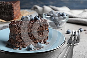 Delicious fresh chocolate cake served with blueberries on table