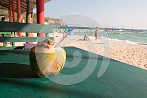 A delicious fresh coconut drink on the green table.