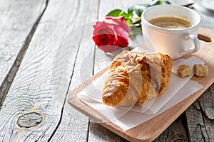 Delicious fresh croissants with coffee and rose