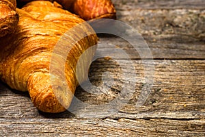 Delicious, fresh croissants isolated on wooden board. French breakfast concept