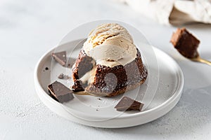 Delicious fresh fondant with hot chocolate centre and ice cream scoop on the plate. Lava cake recipe, menu. Close up