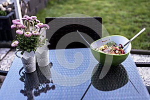 Delicious fresh healthy salad green bowl with salad spoon food standing on a the table with flowers