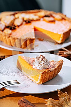 Delicious Fresh Homemade Thanksgiving Pumpkin Pie with a sliced wedge ready to be eaten