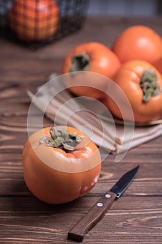 Delicious fresh persimmon fruit on wooden table.