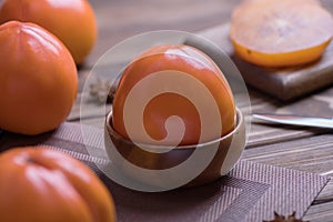 Delicious fresh persimmon fruit on wooden table.