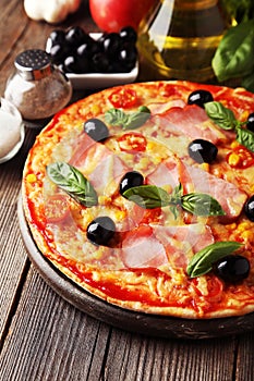 Delicious fresh pizza on brown wooden background.