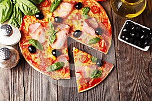 Delicious fresh pizza on brown wooden background.