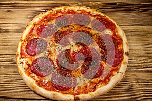 Delicious fresh pizza with sausage and cheese on wooden table