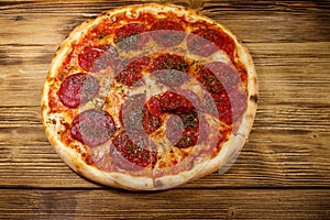 Delicious fresh pizza with sausage and cheese on wooden table