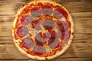 Delicious fresh pizza with sausage and cheese on wooden table. Top view