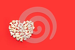 Delicious, fresh popcorn on a red background. Top view, place for text