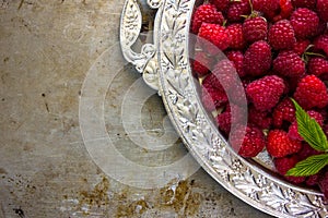 Delicious Fresh raspberries in vintage silver plate vitamins healthy food vegan ingredients. Selective focus