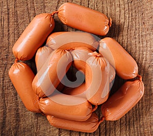 Delicious fresh raw sausages isolated on the wooden background