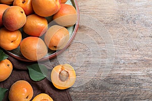 Delicious fresh ripe apricots on wooden table, flat lay. Space for text